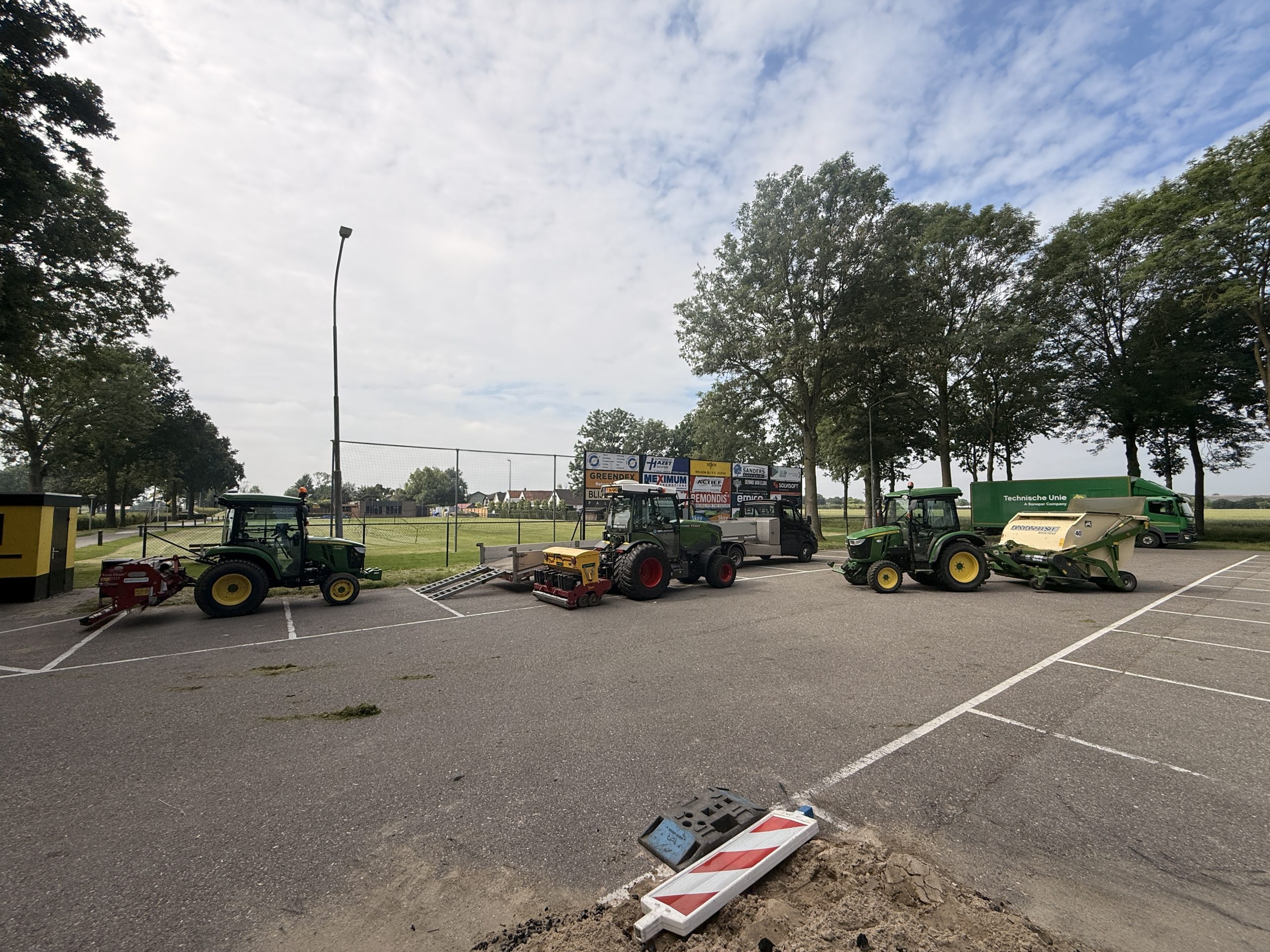 Machines van Grastotaal opgesteld voor sportveldonderhoud bij een voetbalclub